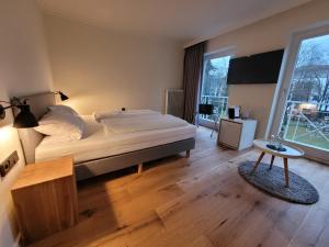 een slaapkamer met een groot bed en een groot raam bij Das Parkhotel in Bad Wörishofen