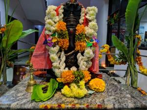 a statue covered in flowers on a table at Hotel Varsha Hampi in Hampi