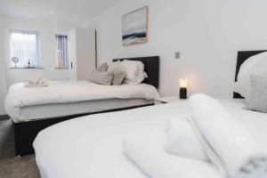 a white room with two beds and a table at Stunning Luxury Stay by VICHY in Hull