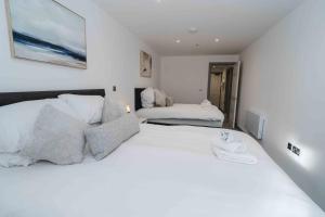 a white bedroom with two beds and a couch at Stunning Luxury Stay by VICHY in Hull