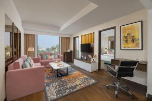 Fortune Park Aligarh-Member ITC's hotel group في عليكره: غرفة معيشة مع أريكة وردية وكرسي