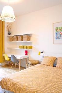 a bedroom with a bed and a table and a desk at Chez Frida - Sublime appartement - Centre Voiron in Voiron