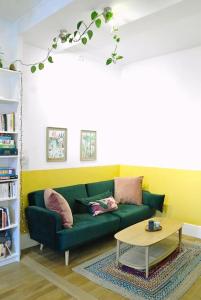 a living room with a green couch and a table at Chez Frida - Sublime appartement - Centre Voiron in Voiron