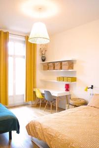 a bedroom with a bed and a desk and a table at Chez Frida - Sublime appartement - Centre Voiron in Voiron