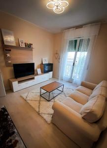 sala de estar con sofá blanco y TV en EDC home con parcheggio e self check in, en Casalecchio di Reno