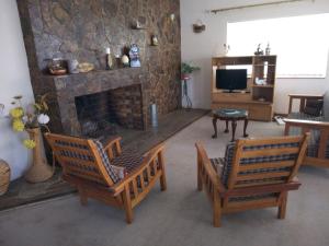 BrandvleiAccommodation Kolarita's Guesthouse, Brandvlei, NC的有两把椅子和一个壁炉的客厅