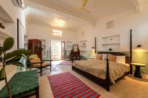 a bedroom with a bed and a chair and a table at Sum Jaipur in Jaipur