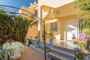 une maison avec une table et des chaises sur une terrasse dans l'établissement Bahamas III -Sant Joan-, à San Juan de Alicante