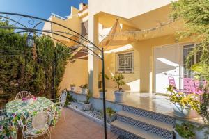 ein Haus mit einem Tisch und Stühlen auf einer Terrasse in der Unterkunft Bahamas III -Sant Joan- in San Juan de Alicante