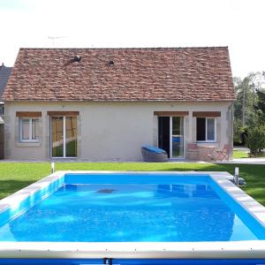 una piscina azul frente a una casa en L'As de Seur, en Seur