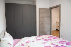 a bedroom with a bed with pink flowers on it at Residenza Garibaldi in Molveno