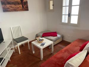 a living room with a couch and a table at Studio cosy dans le centre-ville historique in LʼIsle-sur-la-Sorgue