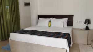 una camera da letto con un grande letto con lenzuola bianche di Sinali Villa a Habaraduwa Central