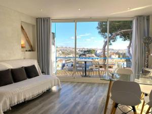 1 dormitorio con cama y vistas a un balcón en TUSQUETS - Apartamento con vistas al mar, en Cadaqués