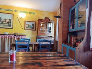 comedor con mesa de madera y sillas azules en Locanda D'Ogliastra, en Triei