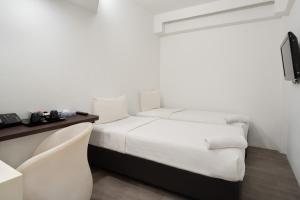 um quarto branco com uma cama e uma secretária em Lion Peak Dickson em Singapura