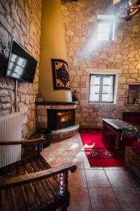 a living room with a fireplace and a tv at Guesthouse Armakas in Kalavrita