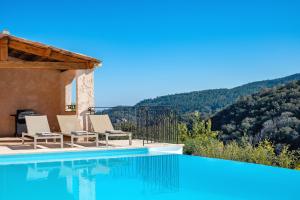 een villa met een zwembad met bergen op de achtergrond bij Villa Baladou in Fréjus