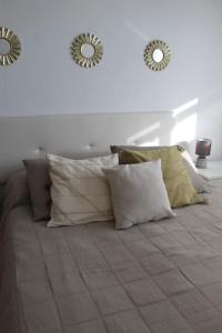 - un lit avec des oreillers et 2 miroirs sur le mur dans l'établissement Apartamento en Los Arenales, à Alicante