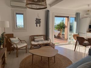 una sala de estar con sillas y una mesa en Le Mazet au Lavandou, en Le Lavandou