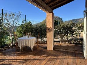 una mesa y sillas en una terraza de madera en Le Mazet au Lavandou, en Le Lavandou
