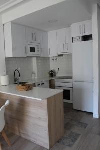 La cuisine est équipée de placards blancs et d'un réfrigérateur blanc. dans l'établissement Apartamento en Los Arenales, à Alicante
