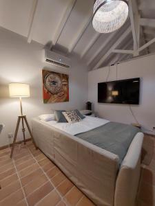 um quarto com uma cama grande e uma televisão em Azenha da Duquesa em Sintra