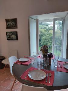 a dining room table with red napkins and a large window at Azenha da Duquesa in Sintra