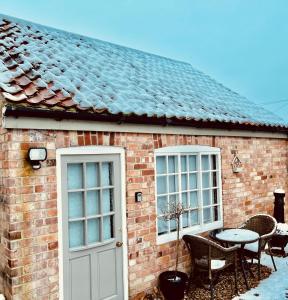 uma casa de tijolos com uma mesa e duas janelas em East Bridgford Coach House Inc Spa and Treatments em East Bridgford