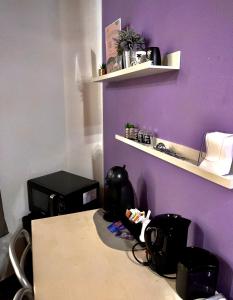 a room with a purple wall and a desk with a computer at CQ Rooms Verona in Verona