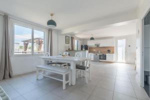 Una cocina y un comedor con una mesa y sillas blancas. en L'Escampette - A 650m de la plage, en Saint-Nazaire 9 fotos más