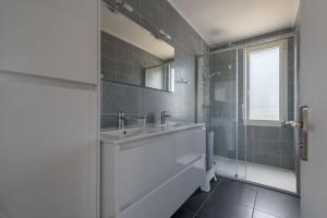 La salle de bains est pourvue d'un lavabo et d'un miroir. dans l'établissement L'Escampette - A 650m de la plage, à Saint-Nazaire