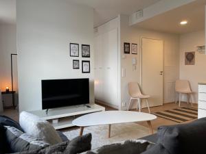 - un salon avec un canapé et une télévision dans l'établissement Uusi kaksio Kaarinan keskustassa, à Kaarina