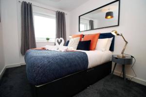 a bedroom with a bed with orange and blue at Vibrant 2 Br Apartment close to Cardiff Central in Cardiff