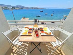 a table with two plates of food on a balcony with the ocean at Midilli Konak Foca in Foça
