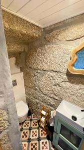 Quinta da Cumieira Nova في سيا: حمام به مرحاض وجدار حجري