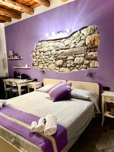 a bedroom with a bed and a stone wall at CQ Rooms Verona in Verona