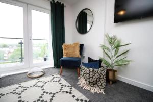 a living room with a blue chair and a mirror at Vibrant 2 Br Apartment close to Cardiff Central in Cardiff