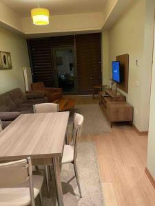 a living room with a table and a tv at Atasehir rezidans kendi eviniz gibi rahat in Istanbul