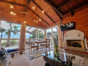 a living room with a table and a fireplace at Ξύλινο Chalet Κτήμα Παππά in Livadeia