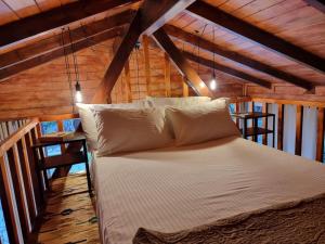 a bed in a room with wooden ceilings at Ξύλινο Chalet Κτήμα Παππά in Livadeia