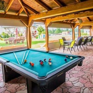a pool table on a patio with awning at La Passion Pokoje Domki Apartamenty in Sarbinowo