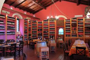 a restaurant with tables and chairs and shelves of wine bottles at Agriturismo Roccadia in Carlentini