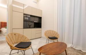 Duas cadeiras e uma mesa numa sala de estar em 18Hanza Tower Platinium Apartments POOL SAUNA JACUZZI em Szczecin