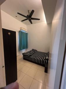 een kamer met een bed en een plafondventilator bij Home Sweet Home in Seremban