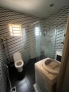 een badkamer met een toilet en een glazen douche bij Home Sweet Home in Seremban