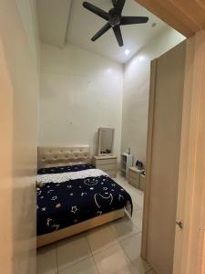 een slaapkamer met een bed en een plafondventilator bij Home Sweet Home in Seremban