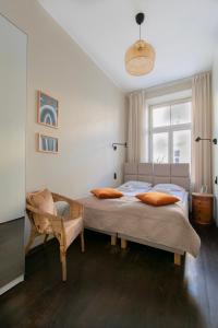 een slaapkamer met 2 aparte bedden en een stoel bij Apartments Wróblewskiego Street in Krakau