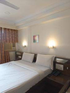 sypialnia z dużym białym łóżkiem z 2 poduszkami w obiekcie Hotel Panorama Resorts w mieście Mahabaleshwar