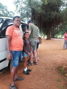 a group of people standing next to a car at Sea Bay Resort in Wennappuwa